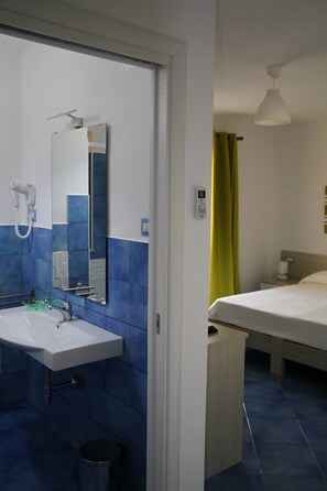 A hotel bathroom with a sink, mirror, and a hairdryer. - Belvedere (Procida)