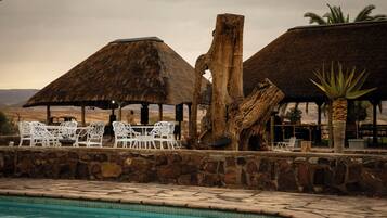 Een buitenzwembad en ligstoelen