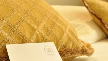 Een hotelkamer met een incheckkaart en een welkomstmagneet op het bed.