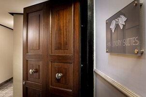 Puiset ovet, joiden yläpuolella on kyltti, jossa lukee: ”HINN LUXURY SUITES”.
