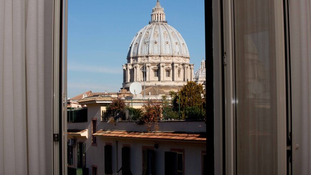 Une vue à travers la fenêtre d’un bâtiment doté d’un grand dôme, qui semble être un édifice historique ou d’une certaine importance.