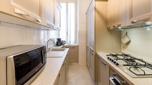 Une cuisine compacte équipée d’un four à micro-ondes, d’un évier et d’une cuisinière à gaz.