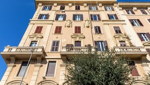 Un immeuble à plusieurs étages, de style architectural classique, doté de balcons et de grandes fenêtres.