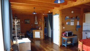 Een houten interieur met een eethoek, keuken en woonruimte.