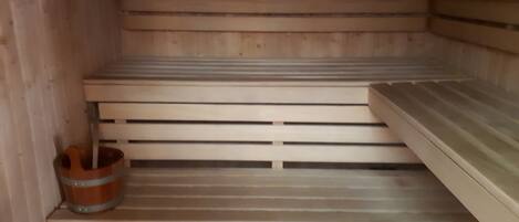 A sauna with wooden benches and a tiled floor.