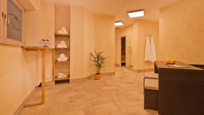 Un hall d’hôtel avec un comptoir d’accueil, une plante en pot et des étagères remplies de serviettes.