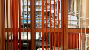 A room with a view of a building with balconies, a pool area, and outdoor furniture. - Central Plaza Studio (Sunny Beach)