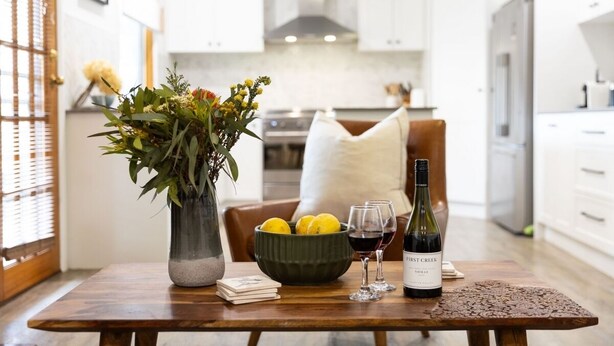 A dining table with a vase of flowers, a bowl of lemons, and a bottle of wine. - Elderslie Country Estate - a stunning country house (Elderslie)