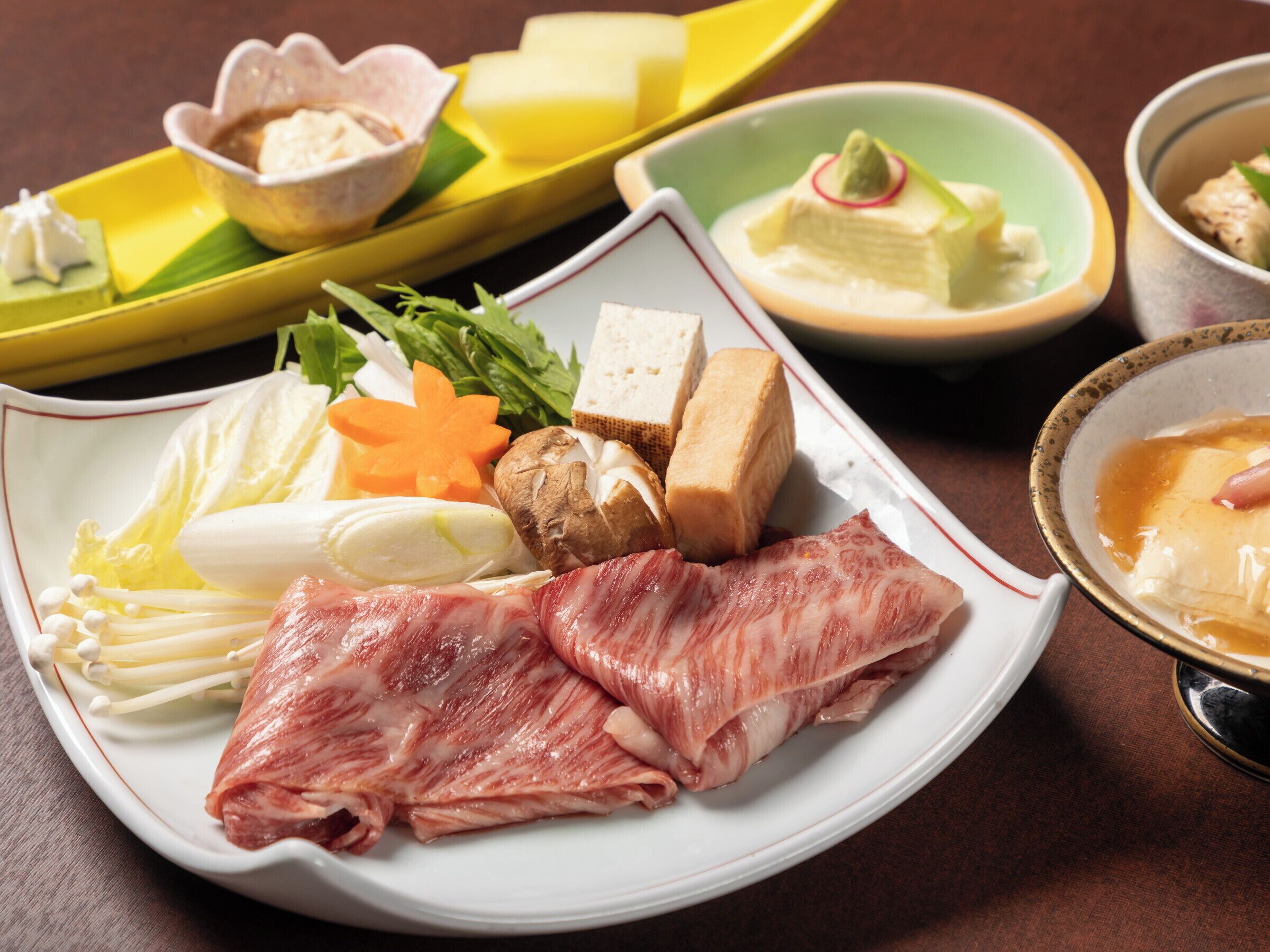 A variety of food items including meat, vegetables, and tofu on a plate.