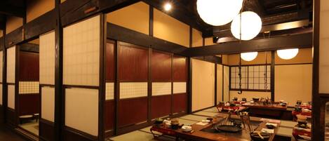 Un restaurant japonais traditionnel avec un sol recouvert de tatamis et de petites tables basses.
