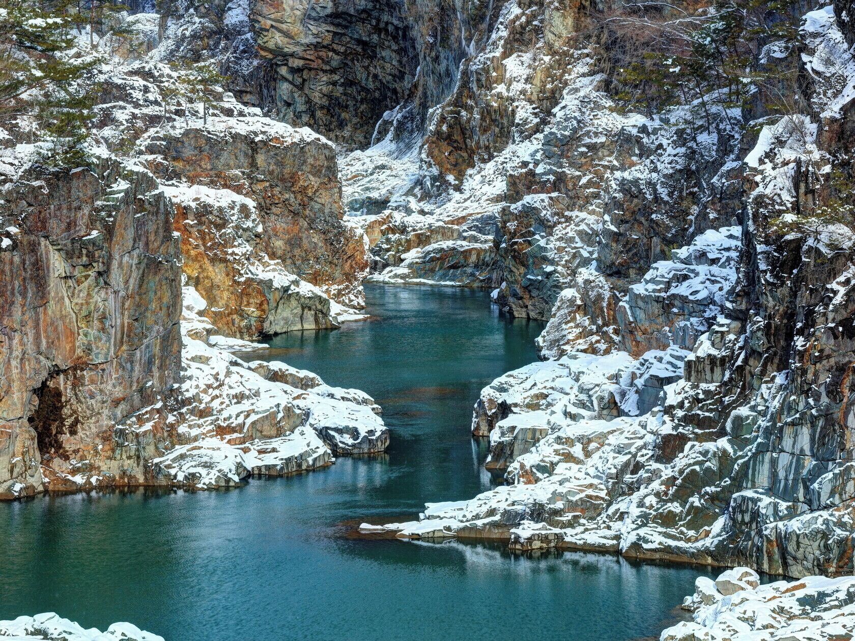 Eine natürliche Landschaft mit einem Fluss, der durch eine felsige Schlucht fließt.
