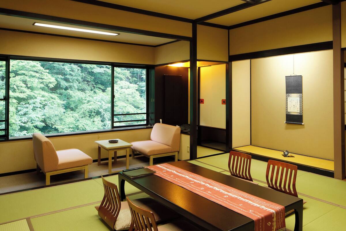 Une pièce de style japonais traditionnel, avec un sol recouvert de tatamis, une table basse et des sièges.