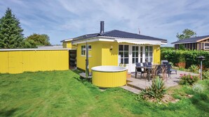 A yellow house with a patio, a hot tub, and a garden. - 2 bedroom pet friendly home in Broager (Broager)