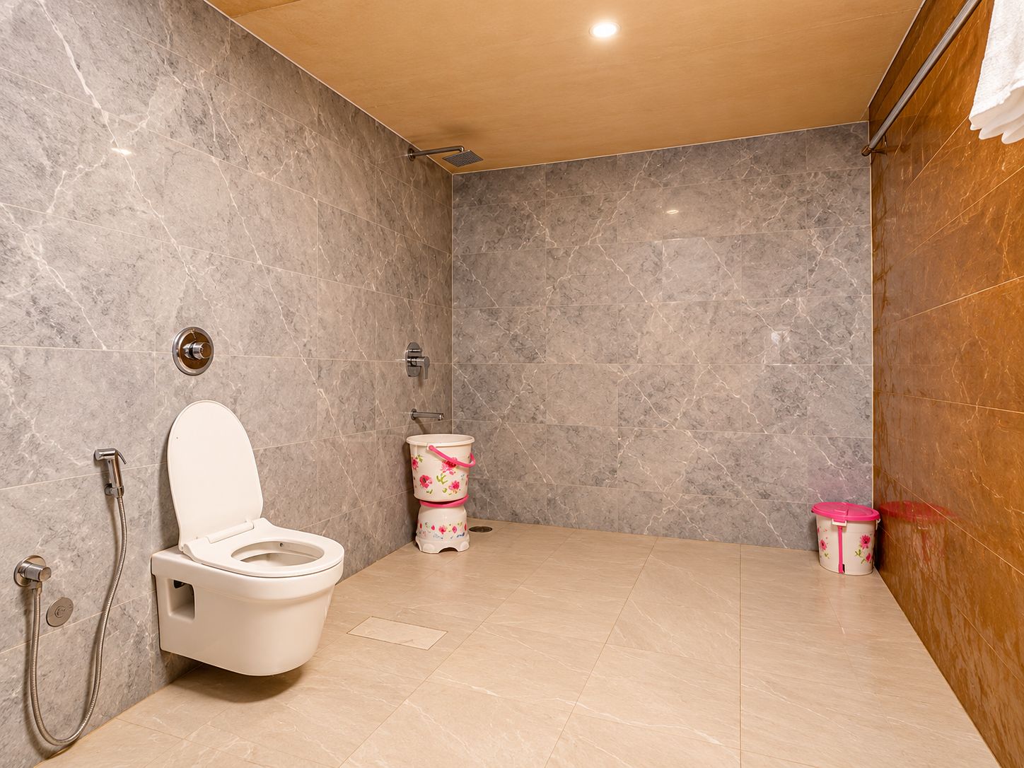 A modern bathroom with a toilet, shower, and sink.