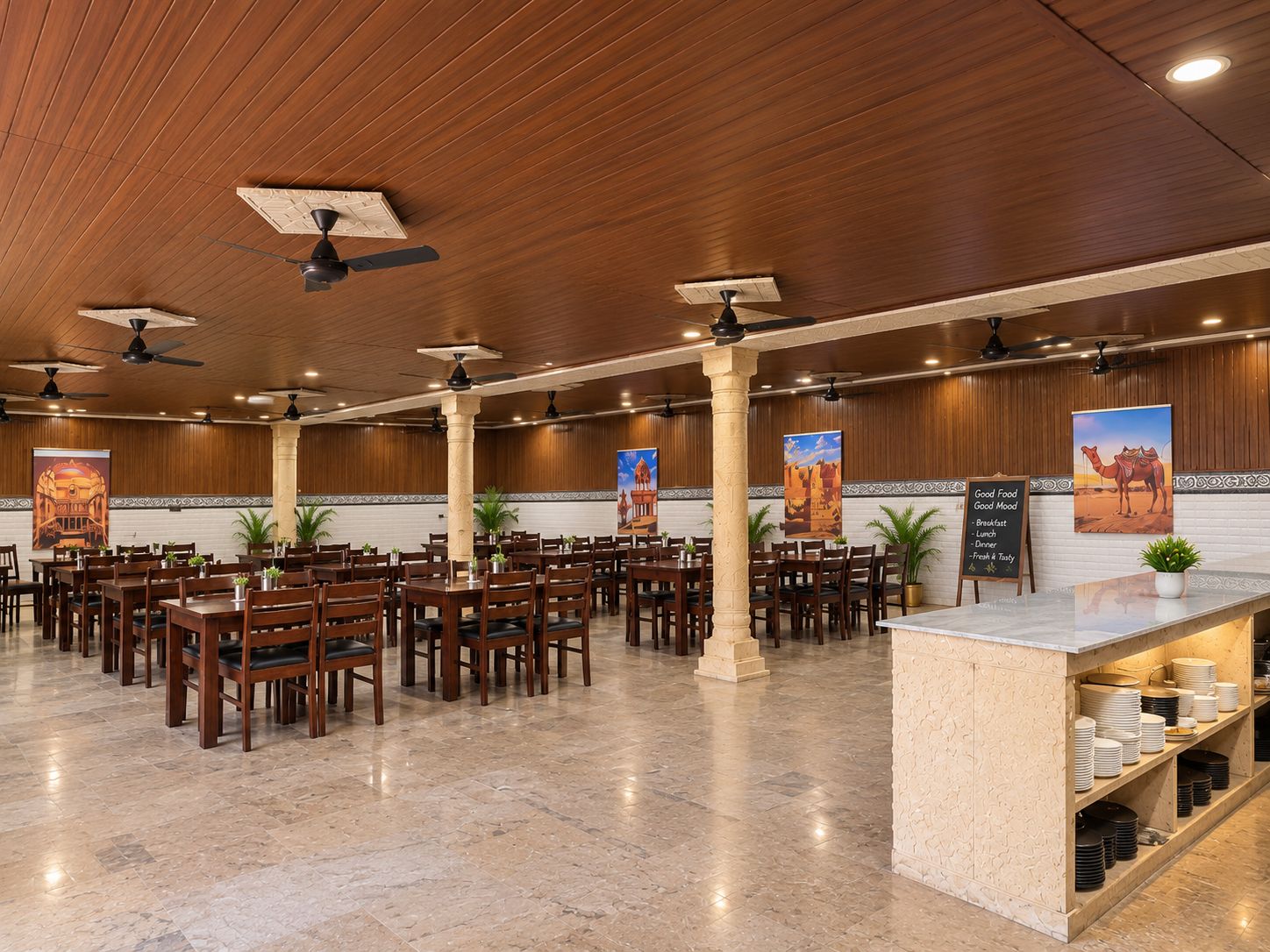 A spacious restaurant with multiple tables and chairs, ceiling fans, and a marble floor.