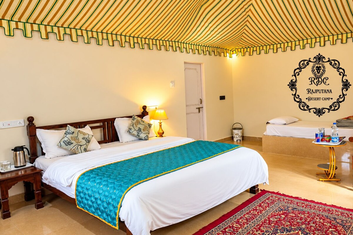 Ein Hotelzimmer mit Bett, Nachttisch, Lampe und einem dekorativen Wandemblem.
