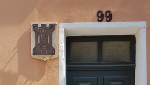 Eine dunkle Holztür mit Zahlenschloss, ein Briefkasten darüber und die Zahl 99 an der Wand.