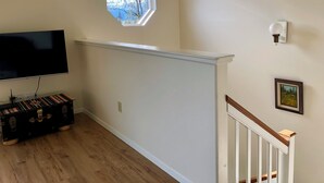 A room with a flat-screen TV, a window, a wall-mounted light, and a framed picture. -  Fern Creek
Convenient location w/ spectacular views! (Homer)