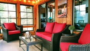 A cozy room with wicker furniture, red cushions, and a glass coffee table. - Lake Days, Bonfires
& Cabin Nights
2 Bedrooms / 2 Bathrooms  (Boulder Junction)