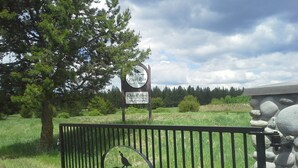 A sign for Quail Run Golf Course with a bird silhouette on a fence.