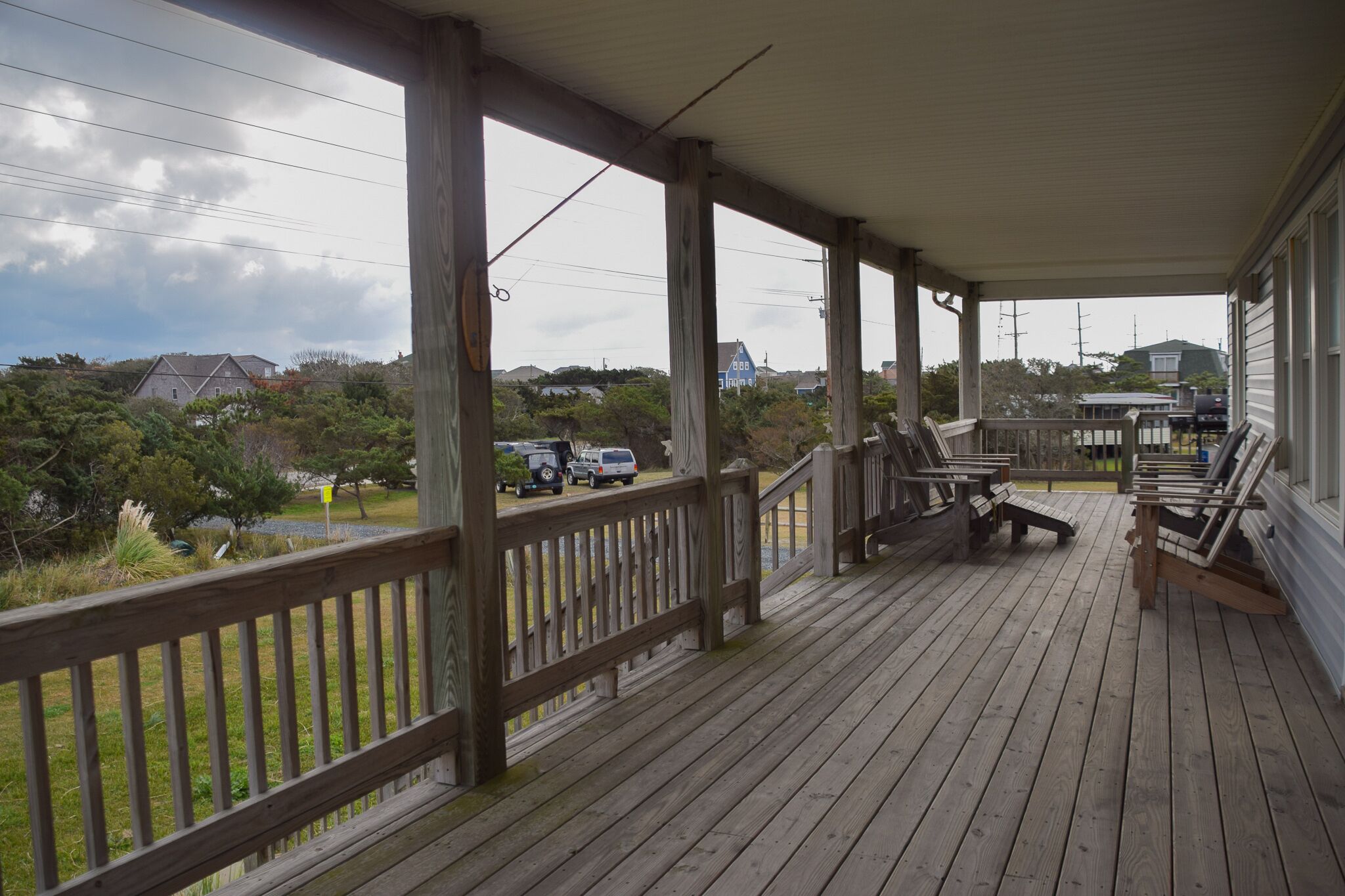 A wooden deck with outdoor seating and a view of a residential area.