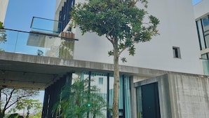 A modern building with a flat roof, large windows, and a tree in front. - Aloe Villa (Wujie)