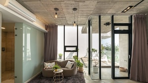 A modern living room with a sofa, a coffee table, and potted plants. - Aloe Villa (Wujie)