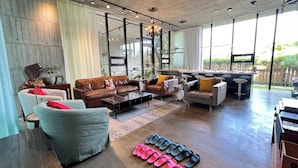 A spacious living area with leather sofas, a coffee table, and a dining area with bar stools. - Aloe Villa (Wujie)