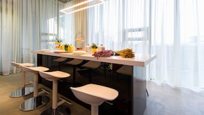 A modern kitchen with a central island, bar stools, and a large window with sheer curtains. - Aloe Villa (Wujie)