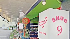A storefront with a sign reading "SNUG 9". - Snug Nine Inn (Hengchun)