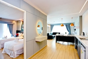 A modern hotel room with two beds, a dining area, and a kitchen. - Le Breeze Resort Hua Hin (Cha-am)