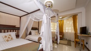 A hotel room with two beds, a TV, and a desk. - Hotel Rudi (Nairobi)