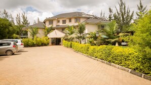 A two-story house with a paved driveway and a well-maintained garden. - Hotel Rudi (Nairobi)