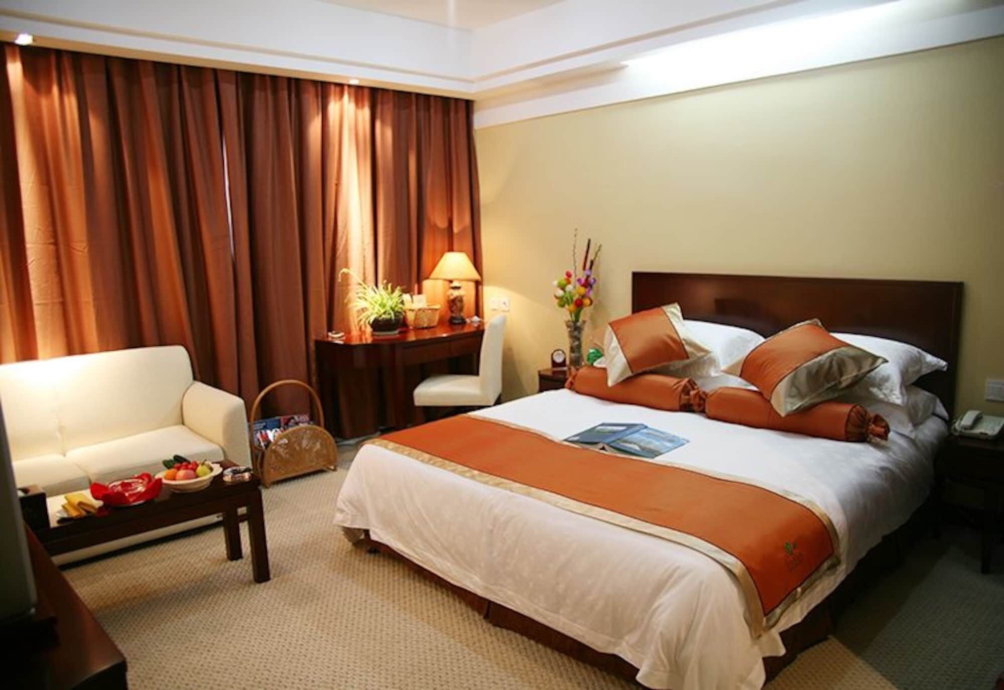 A hotel room with a bed, a sofa, a desk, and a chair.
