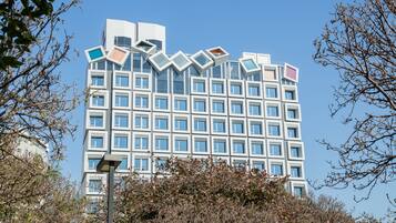 A modern building with a unique geometric facade and multiple windows.