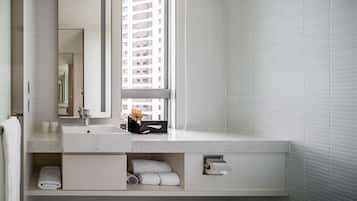 Uma casa de banho moderna com um espelho grande, uma pia e uma janela.