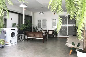 A room with a washing machine, a bench, a table, and potted plants. - 12/14 HOME Studio (Bangkok)