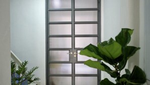 A door with a metal grid pattern, a doorknob, and a mat on the floor. - 12/14 HOME Studio (Bangkok)