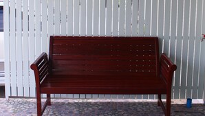 Un banc en bois devant une enseigne d’auberge ornée d’un cœur et d’une représentation de maison.