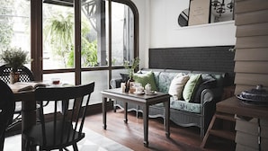 Une pièce confortable avec un canapé, une table et une chaise. Une fenêtre donne sur un paysage verdoyant.