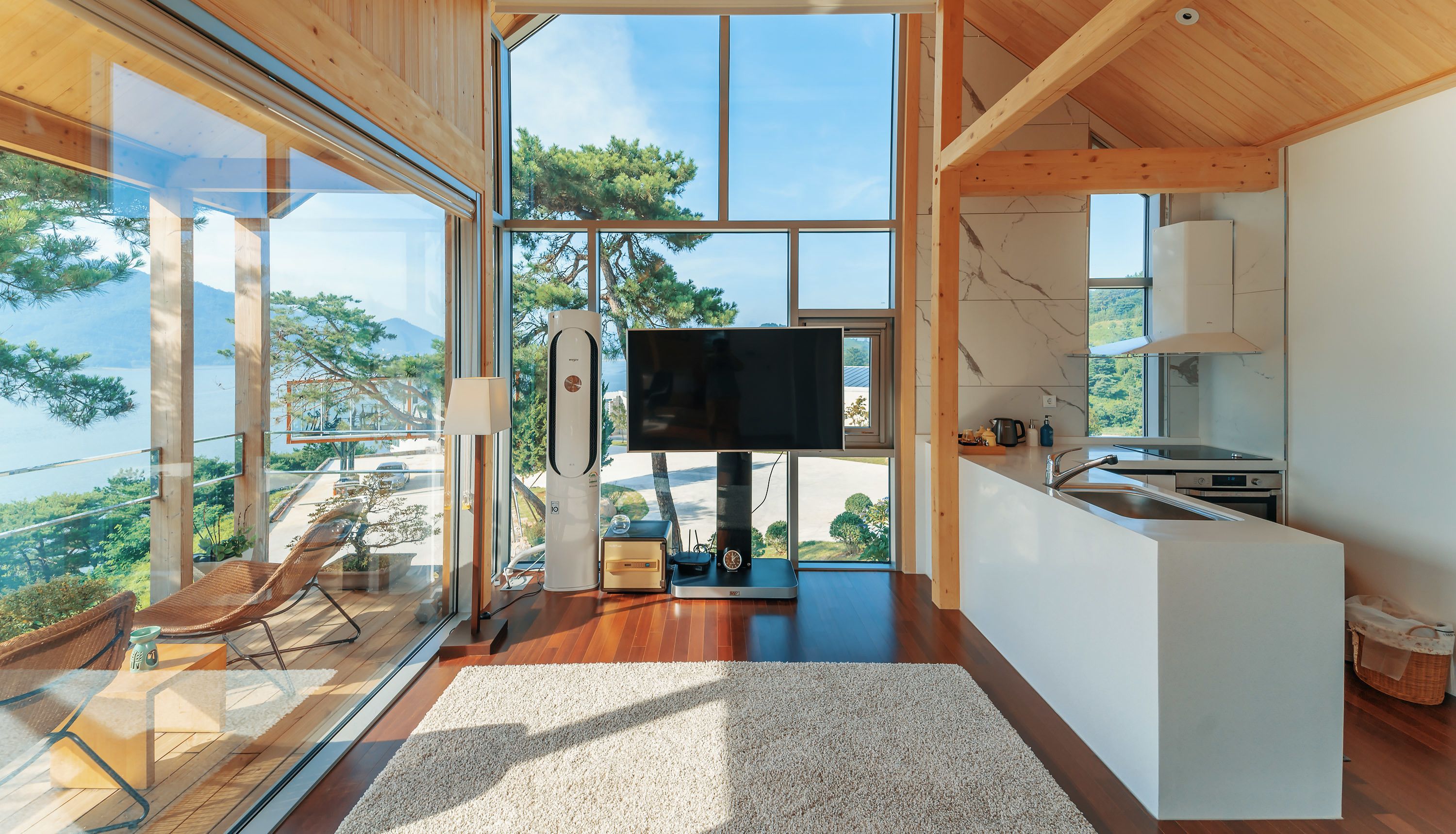 Una cocina moderna con un ventanal grande, un televisor de pantalla plana y un comedor con vistas al exterior.