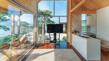 Una cocina moderna con un ventanal grande, un televisor de pantalla plana y un comedor con vistas al exterior.