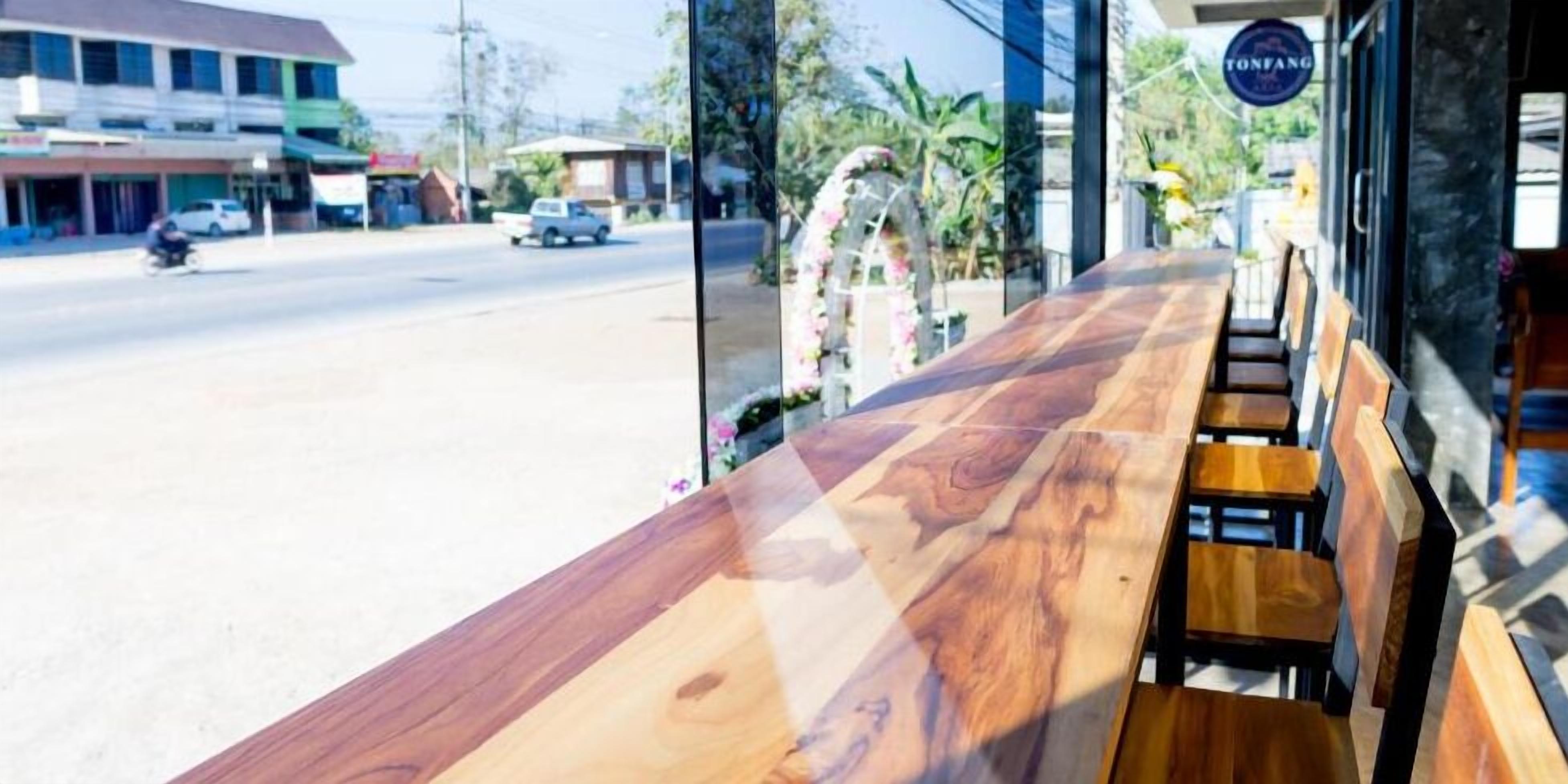 A wooden bench and table with a view of a street and buildings.