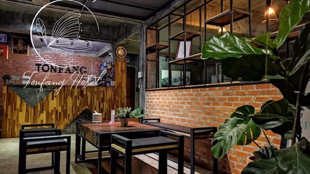 Un interior moderno con paredes de ladrillo visto, detalles de madera y mobiliario de metal negro.
