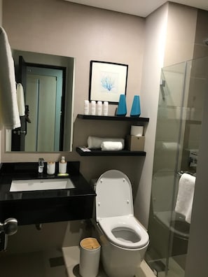A modern bathroom with a black sink, white toilet, and glass shower enclosure. - Park View at Solinea Cebu (Cebu City)