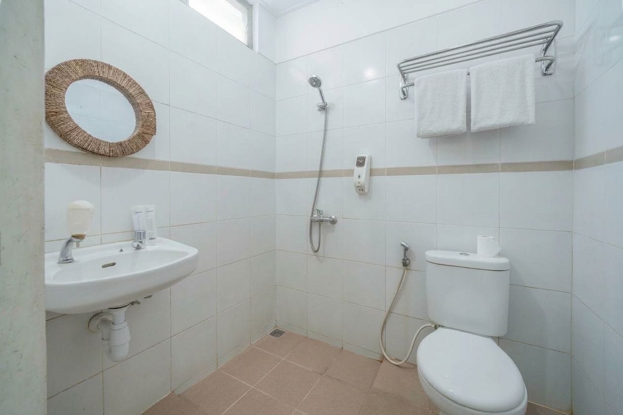 A bathroom with a sink, toilet, shower, and a towel rack.
