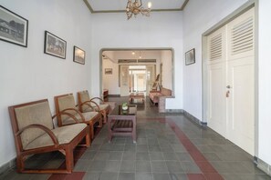 A hallway with seating, a coffee table, and a door.