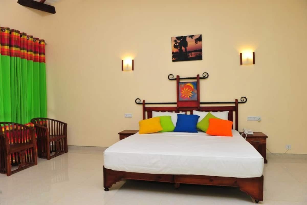 A neatly made bed with colorful pillows, a wooden headboard, and two wall-mounted lights.