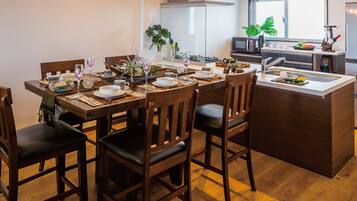 A modern kitchen with a central island, wooden chairs, and a dining table set for four.