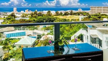 A balcony with a table, two glasses, and a plant.